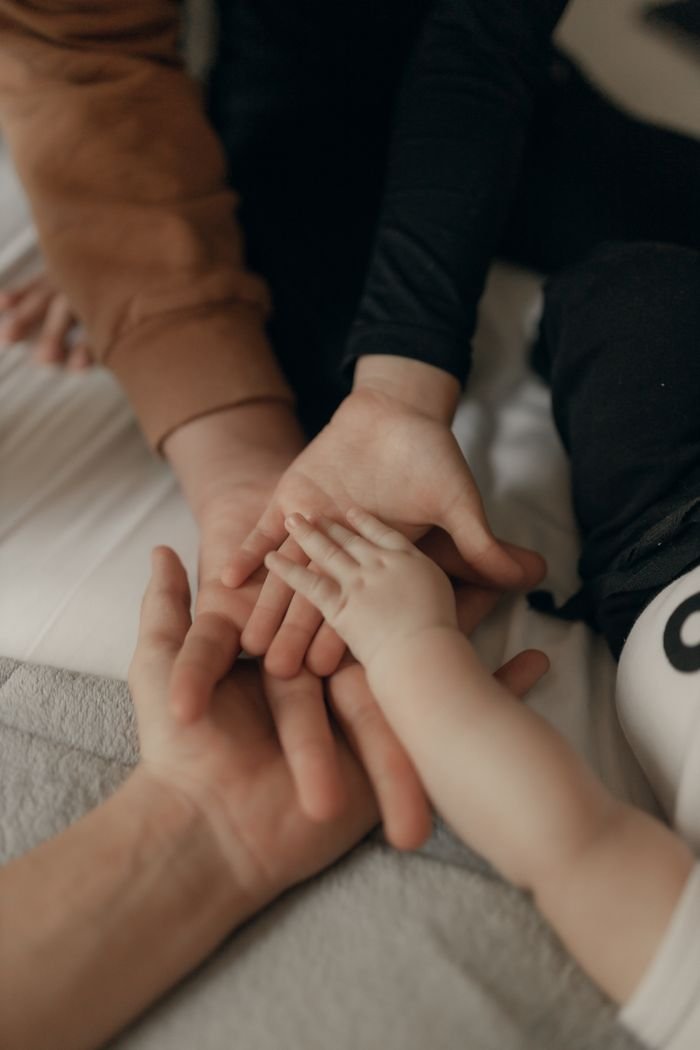 Close-up of a family joining hands, symbolizing unity and love.
